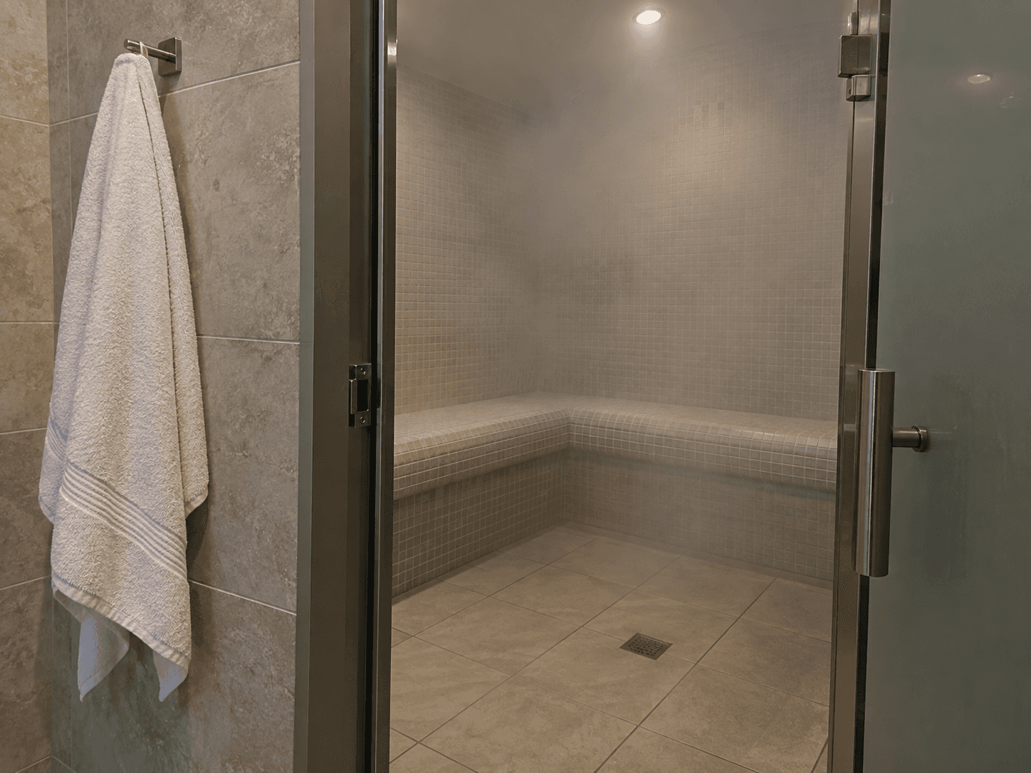 A tiled steam room seen through an open doorway.