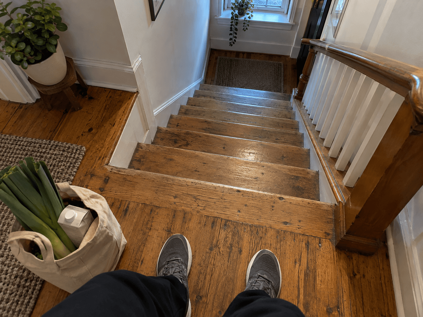 A grocery bag beside trainers on a stair landing.