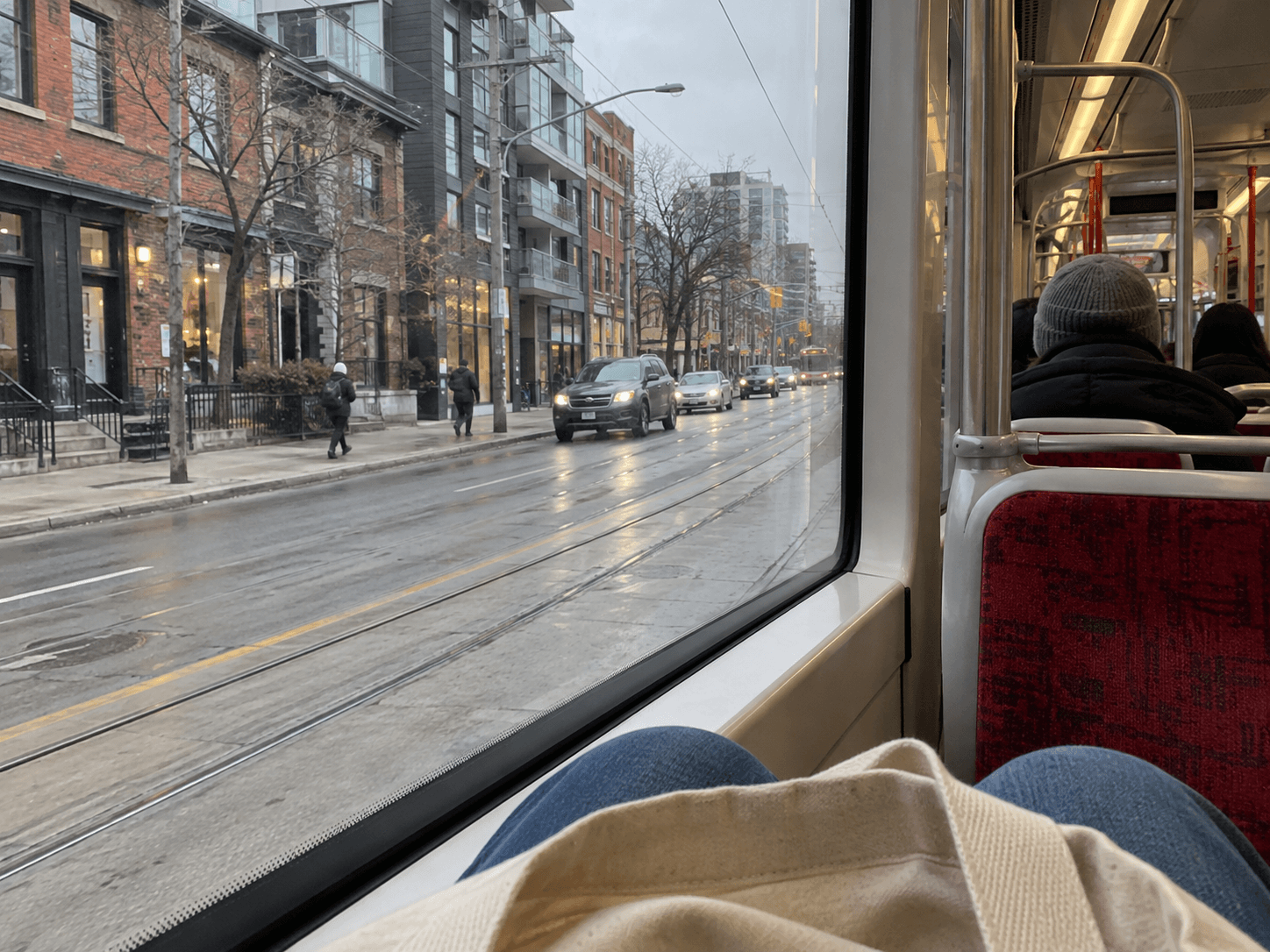 A streetcar window overlooking an ordinary Toronto street.